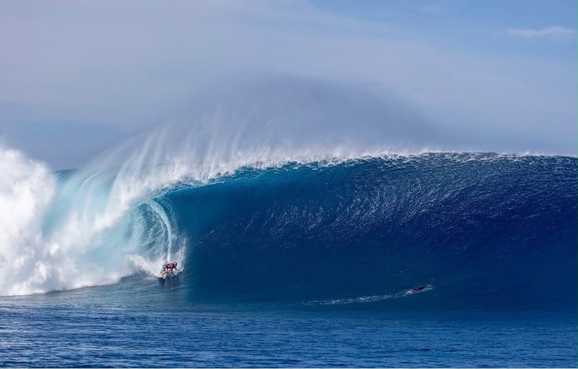 Surfer riding deep inside a large barreling wave