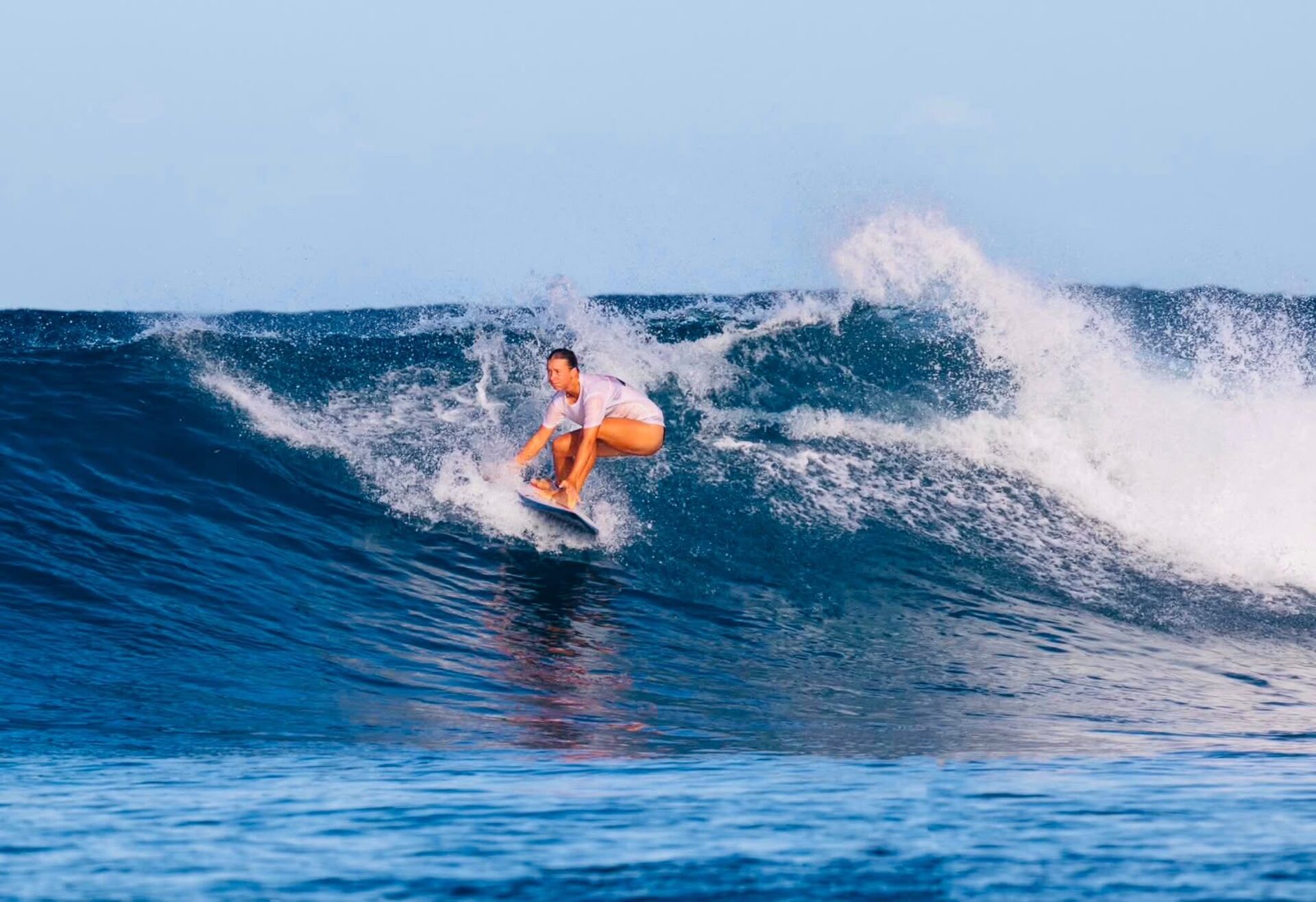Surfer carving a turn on a wave in Fiji